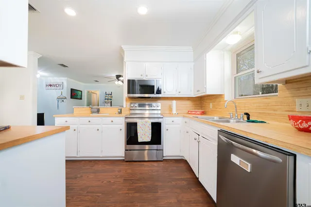 a kitchen with granite countertop white cabinets and white appliances