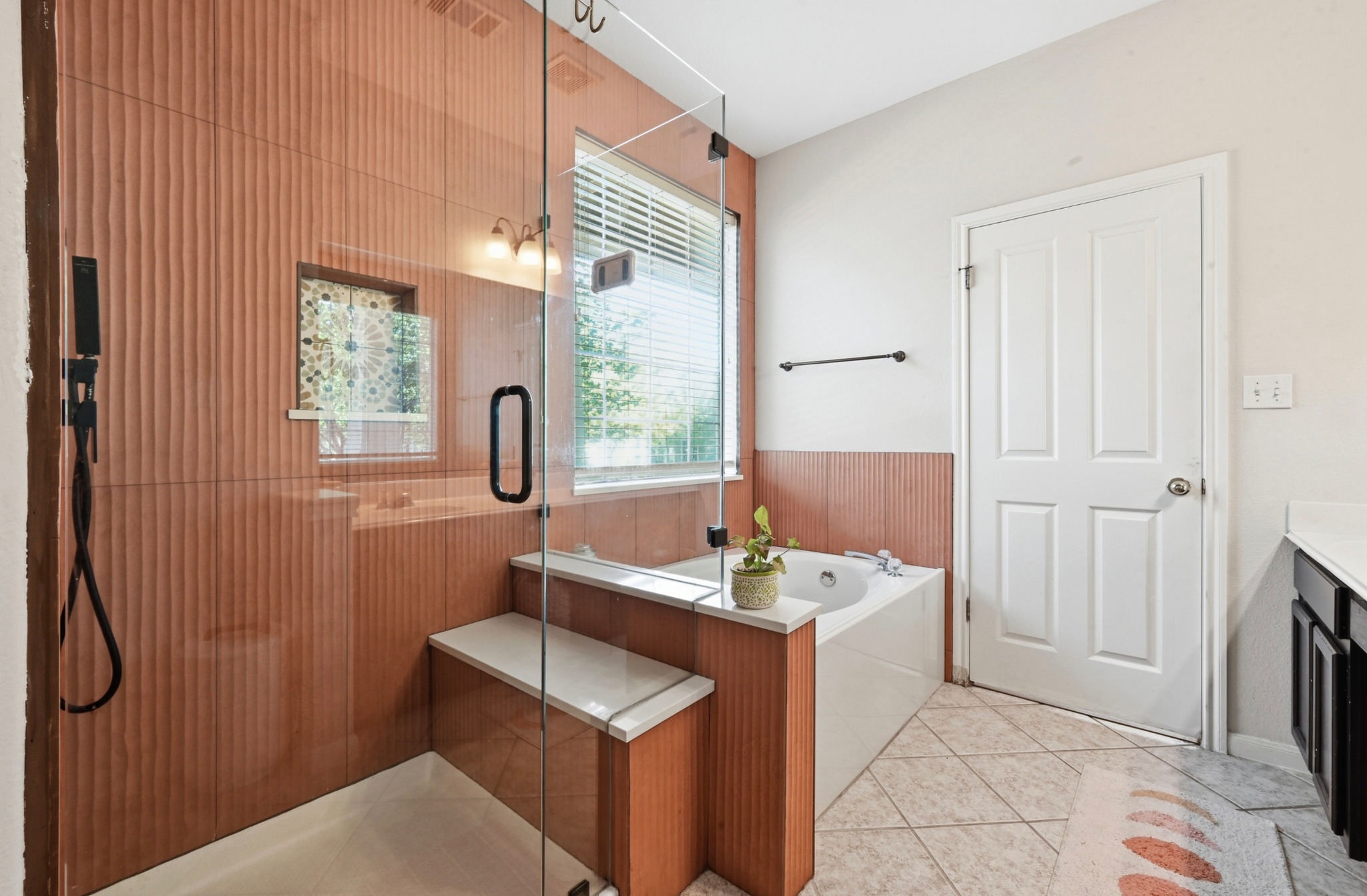 5888 Fergus Kyle, TX 78640 - Photo 17 of 40 A well-lit bathroom features a glass-enclosed shower alongside a deep soaking tub and a built-in bench.