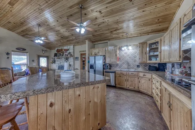 a kitchen with stainless steel appliances granite countertop a sink a stove and cabinets