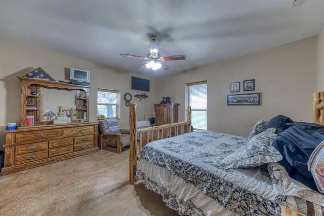 a living room with furniture a ceiling fan and a window
