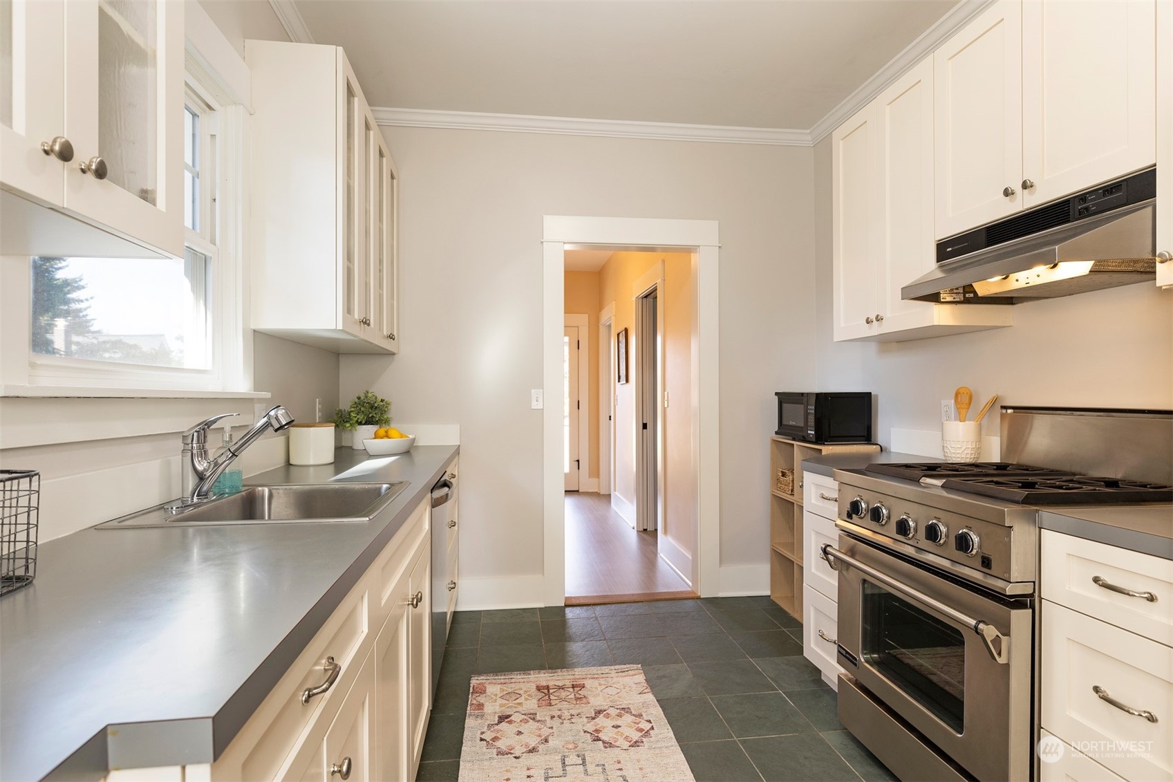 110 North 76th Street Seattle, WA 98103 - Photo 13 of 36 a kitchen with stainless steel appliances granite countertop a sink stove and refrigerator