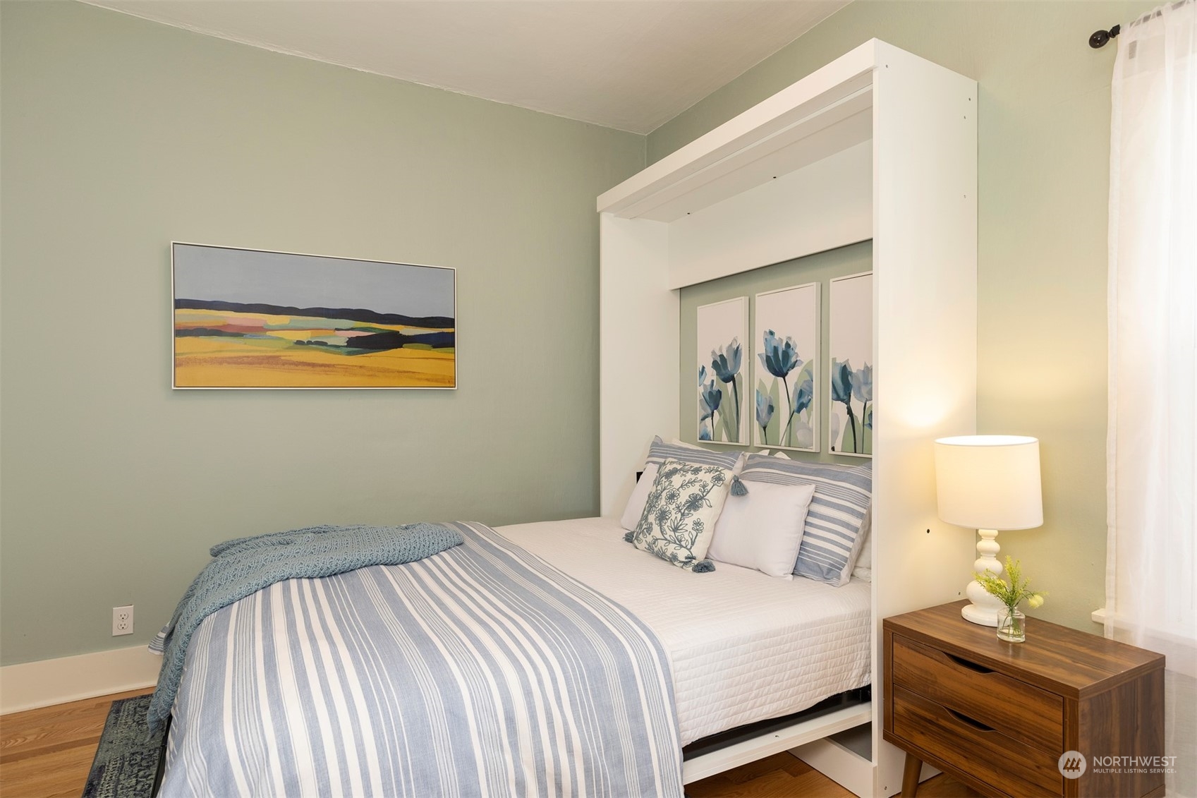 110 North 76th Street Seattle, WA 98103 - Photo 21 of 36 a bedroom with a bed and wooden floor