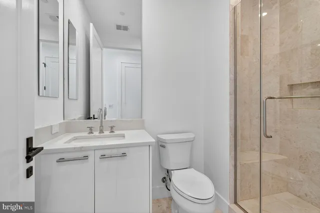 a bathroom with a granite countertop sink toilet and a mirror