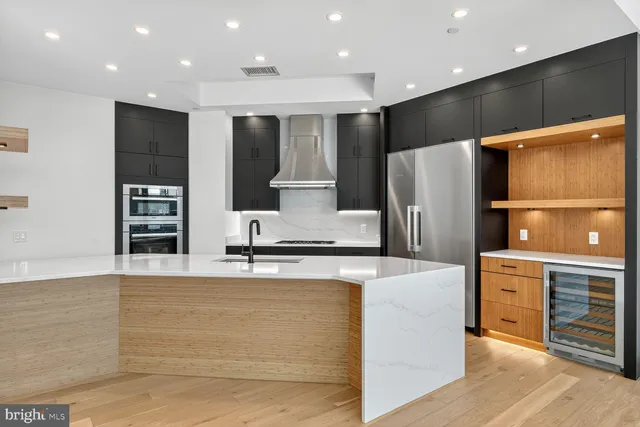 a large kitchen with stainless steel appliances a refrigerator and a stove top oven