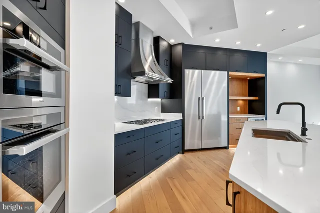 a kitchen with stainless steel appliances a sink stove and refrigerator