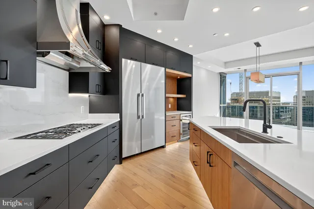 a kitchen with stainless steel appliances kitchen island a sink stove and refrigerator