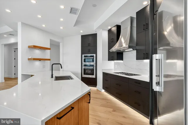 a kitchen with stainless steel appliances granite countertop a refrigerator and a sink