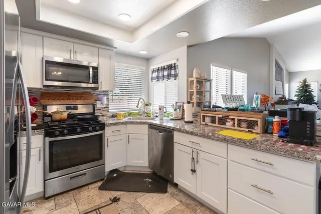 a kitchen with stainless steel appliances kitchen island granite countertop a stove a sink and a microwave