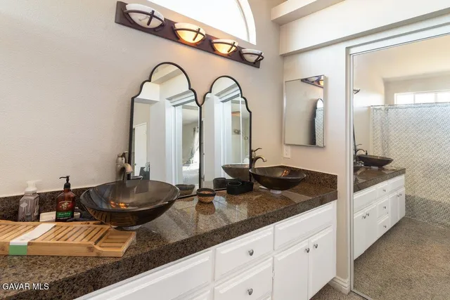 a spacious bathroom with sinks and a mirror