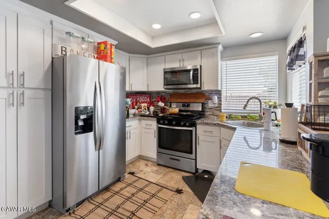 a kitchen with stainless steel appliances a stove a refrigerator and a refrigerator