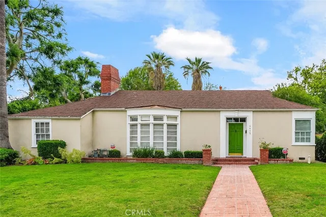 a view of a house with a yard and potted plants