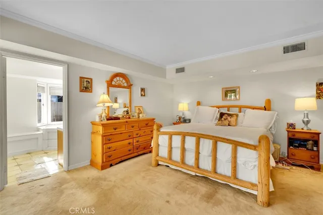 a view of a bedroom with baby bed and lounge chair