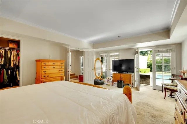 a bedroom with a bed and a flat tv screen next to a window