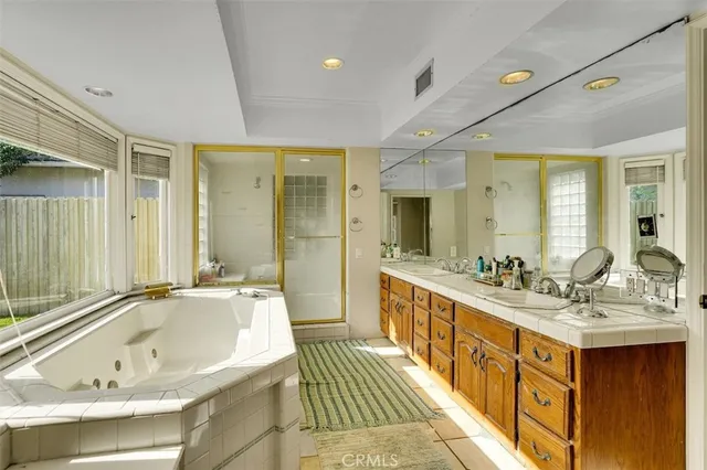 a bathroom with a tub sink shower double vanity