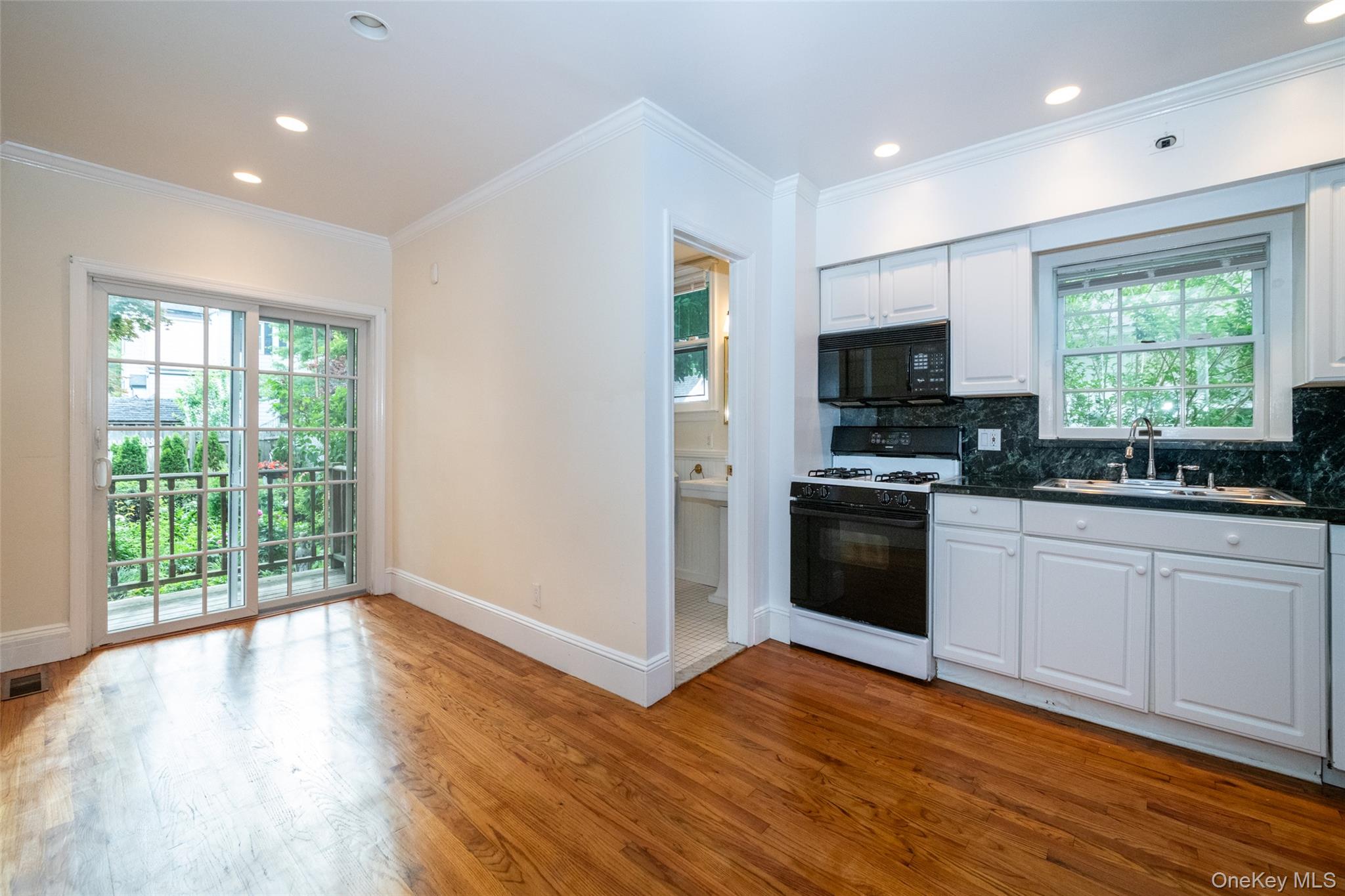 82 Clove Road New Rochelle, NY 10801 - Photo 4 of 39 a kitchen with wooden floors a stove a sink and a window