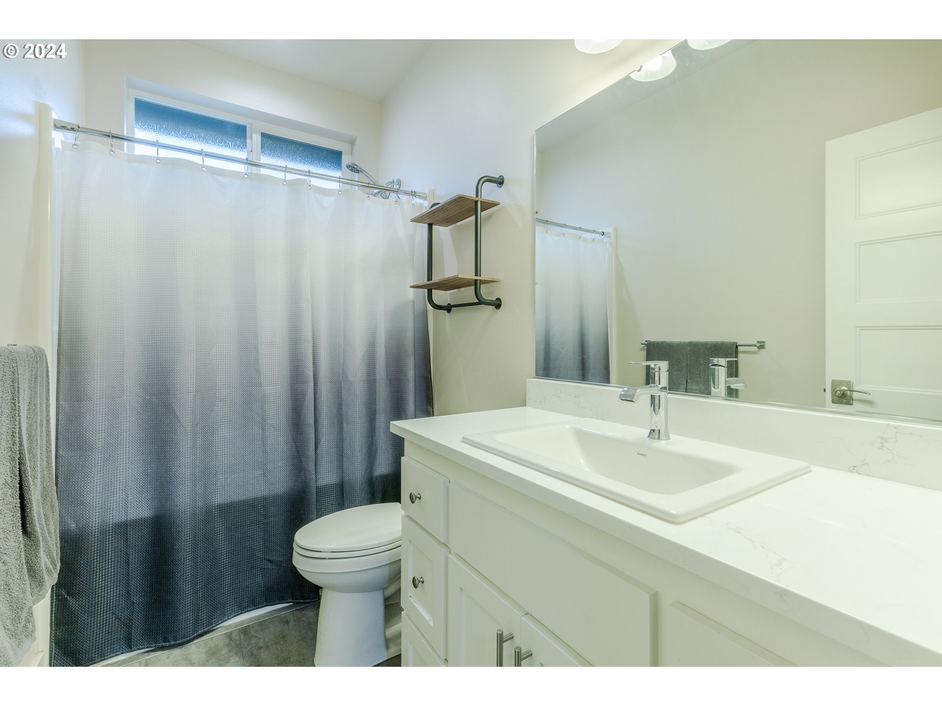 1026 West Olympic Street Springfield, OR 97477 - Photo 22 of 31 a bathroom with a sink toilet a mirror and shower curtain