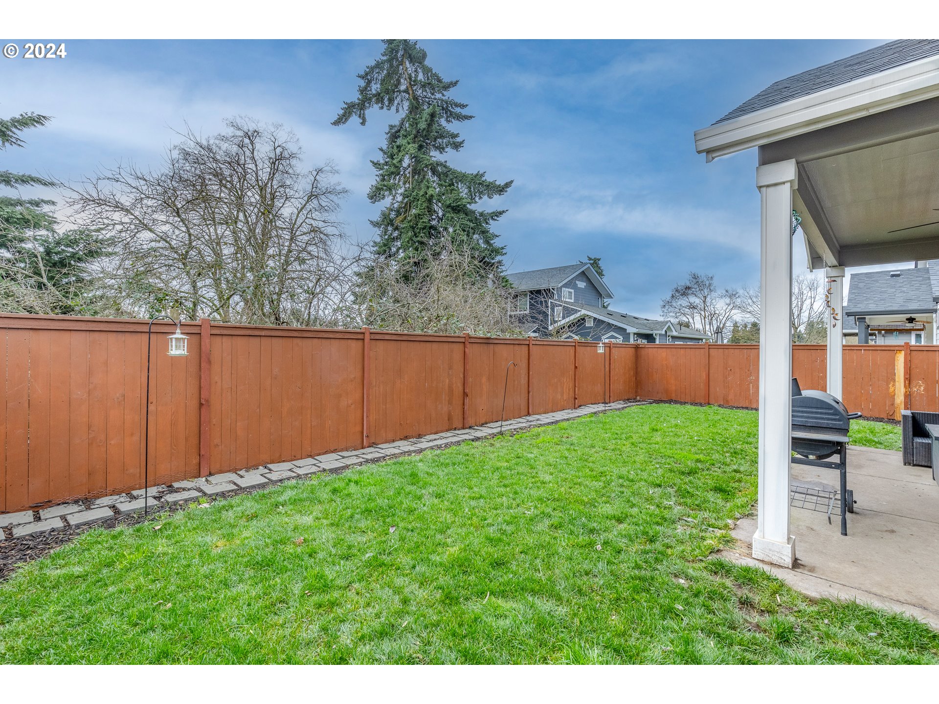 1026 West Olympic Street Springfield, OR 97477 - Photo 31 of 31 a view of backyard with large tree and wooden fence