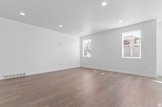 1024 South Tanner Road Santaquin, UT 84655 - Photo 10 of 20 Empty room featuring hardwood / wood-style floors, recessed lighting, and a textured ceiling