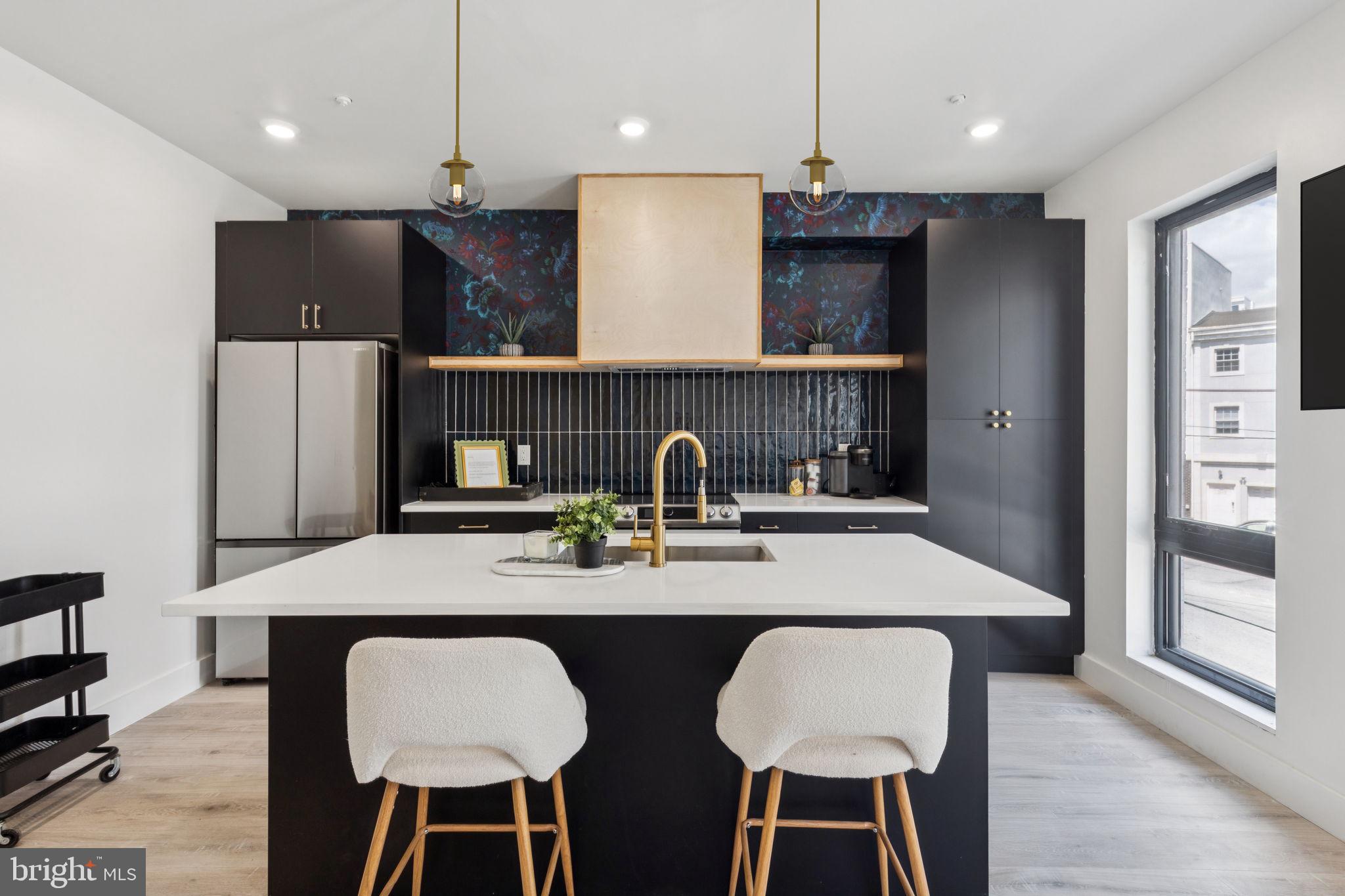 1602 Ridge Avenue, Unit 3 Philadelphia, PA 19130 - Photo 6 of 17 a kitchen with stainless steel appliances granite countertop a kitchen island a stove a table and chairs