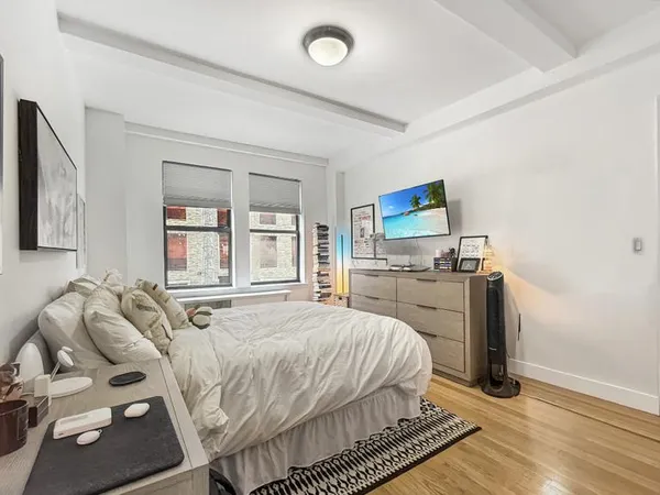 a spacious bedroom with a bed and a flat screen tv