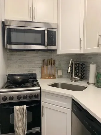 a kitchen with appliances a sink and cabinets
