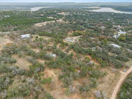 an aerial view of residential houses with outdoor space and trees