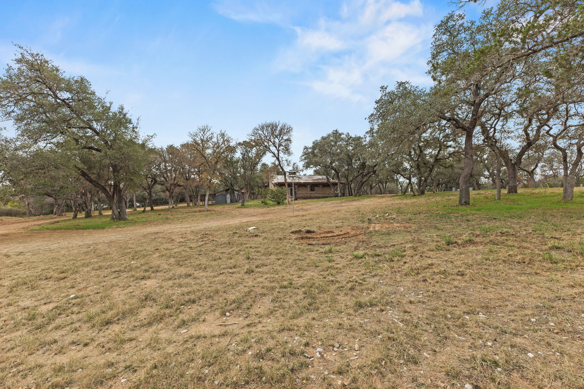 122 Winding Creek Road Spicewood, TX 78669 - Photo 8 of 19 a view of a field with trees in the background