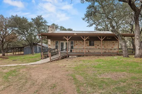 a view of a house with backyard and trees