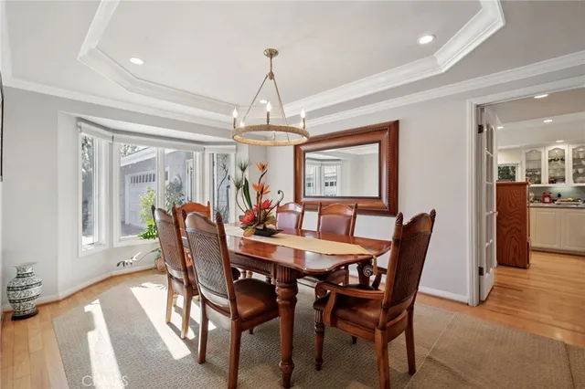 a view of a dining room with furniture a chandelier and wooden floor