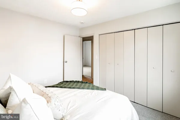 a bedroom with a large bed and a chandelier fan