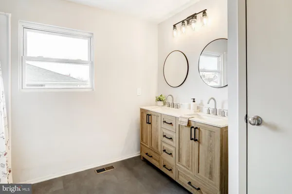 a bathroom with a double vanity sink and a mirror