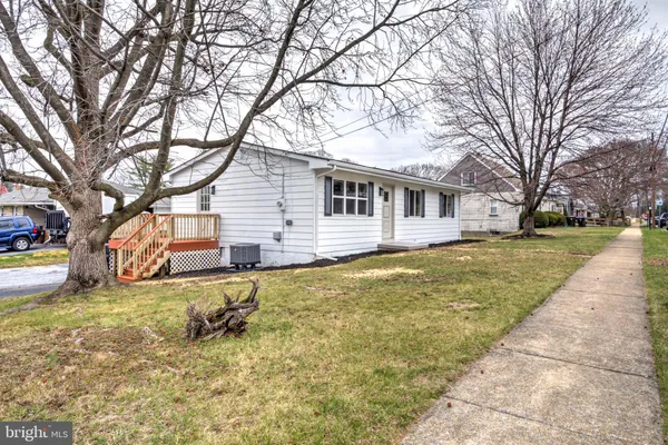 a front view of house with yard and trees around