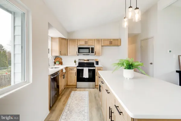 a kitchen with granite countertop a stove a sink and a refrigerator