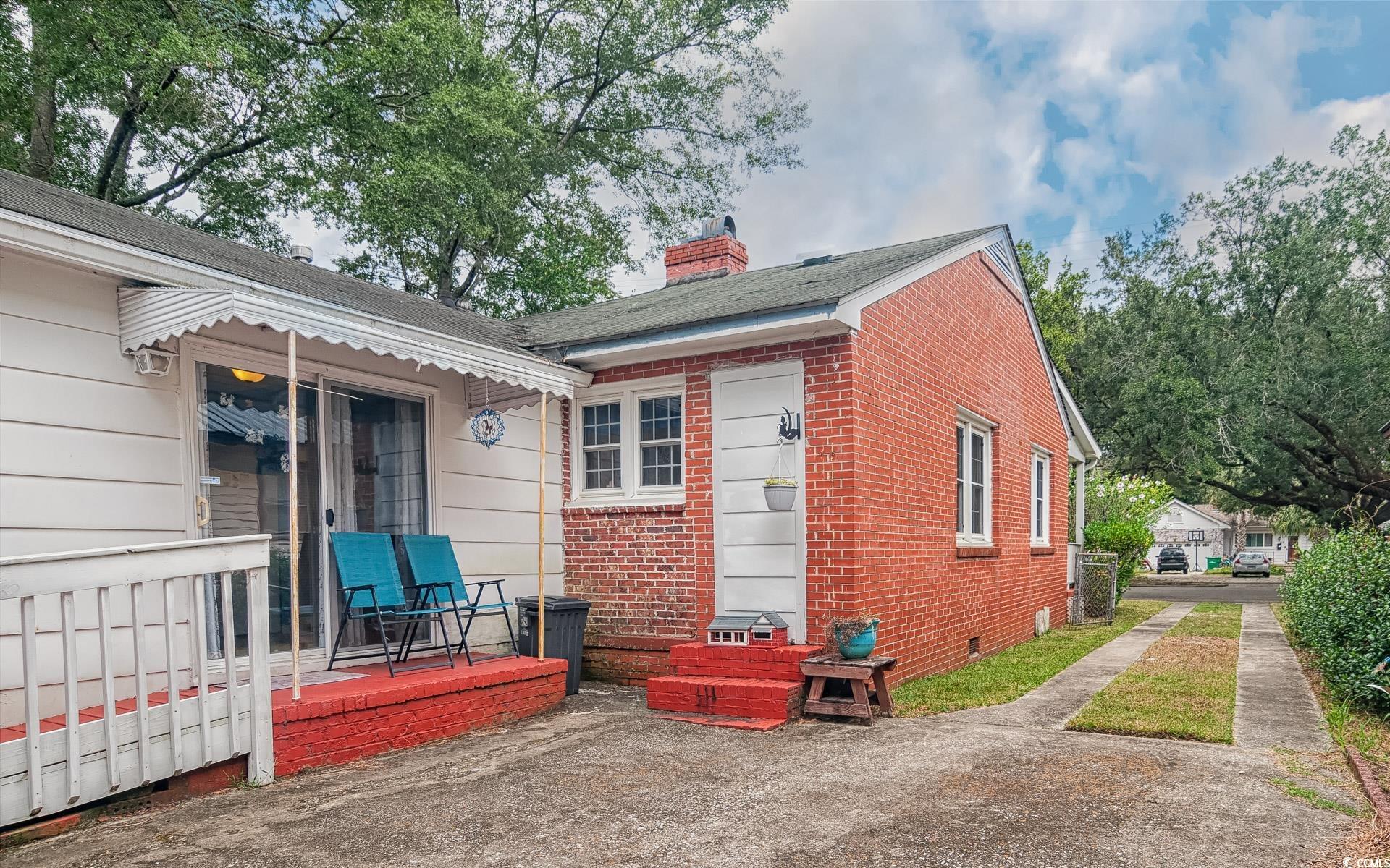 310 St James Street Georgetown, SC 29440 - Photo 19 of 25 Back of house with a chimney, a wooden deck, brick siding, crawl space, and a shingled roof