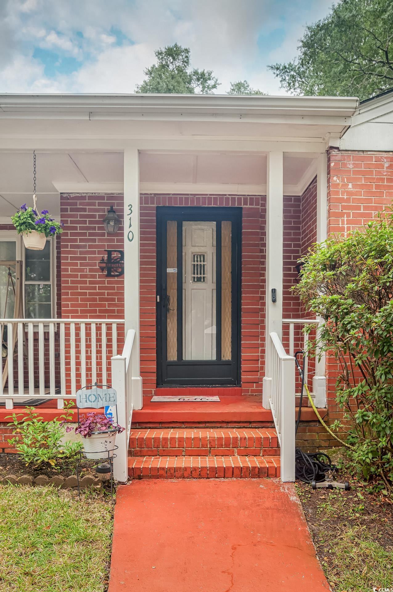 310 St James Street Georgetown, SC 29440 - Photo 3 of 25 View of exterior entry featuring a porch and brick siding