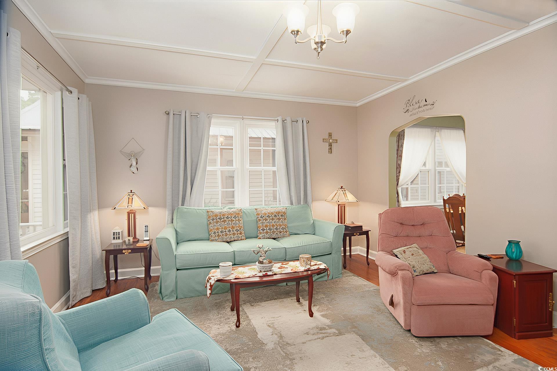 310 St James Street Georgetown, SC 29440 - Photo 5 of 25 Living room with wood finished floors, coffered ceiling, arched walkways, a chandelier, and crown molding