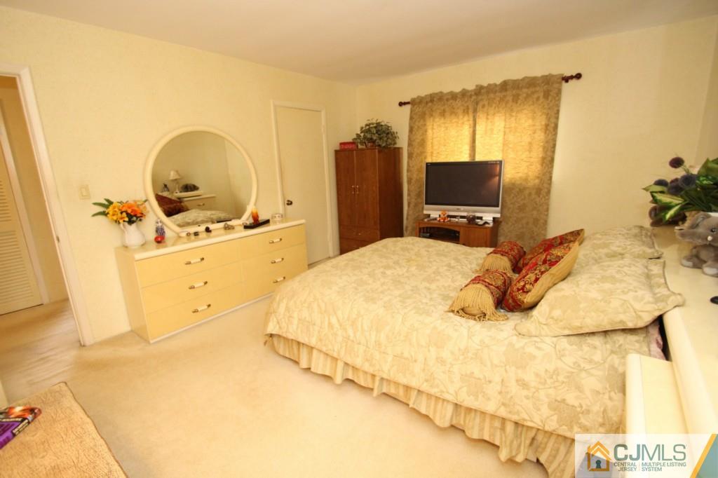 16 Gales Road Edison, NJ 08837 - Photo 14 of 25 a bedroom with a bed and a flat tv screen on dresser
