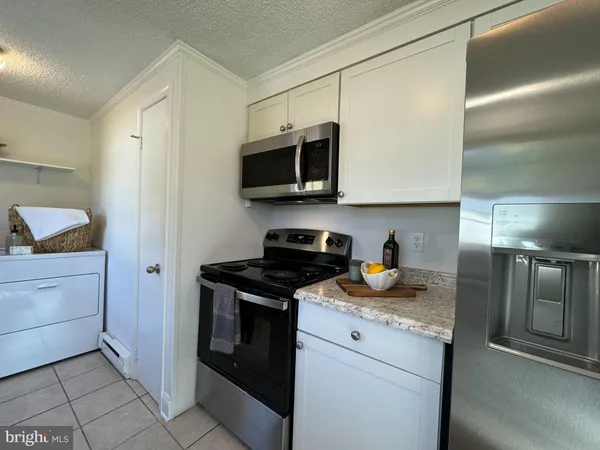 a kitchen with granite countertop a stove and a microwave