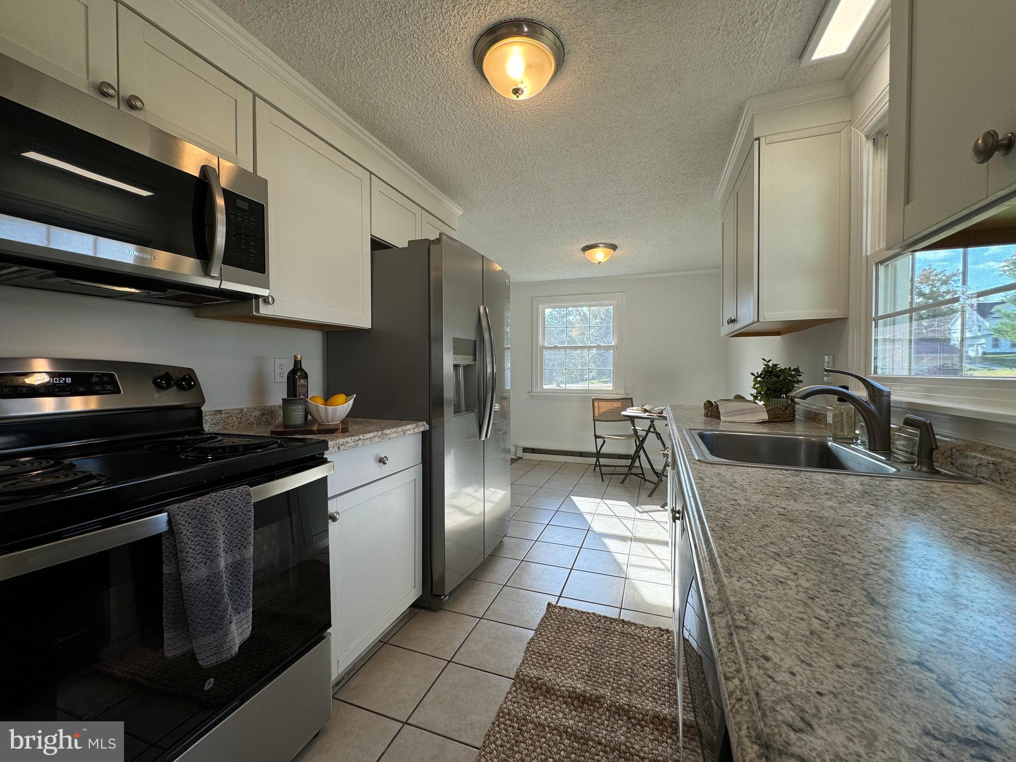 1581 Skinners Turn Road Owings, MD 20736 - Photo 13 of 37 a kitchen with stainless steel appliances granite countertop a stove a sink and a microwave