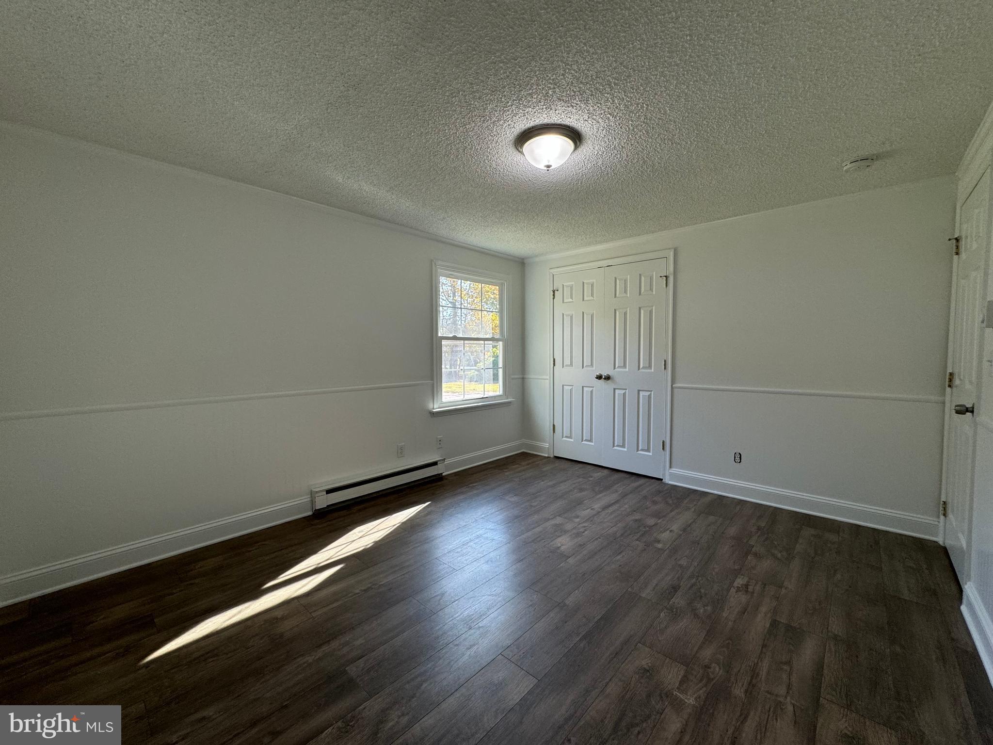 1581 Skinners Turn Road Owings, MD 20736 - Photo 22 of 37 an empty room with wooden floor and windows