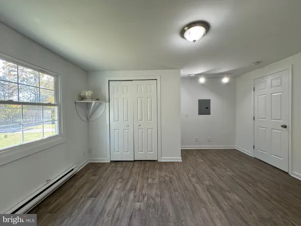 an empty room with wooden floor and a window