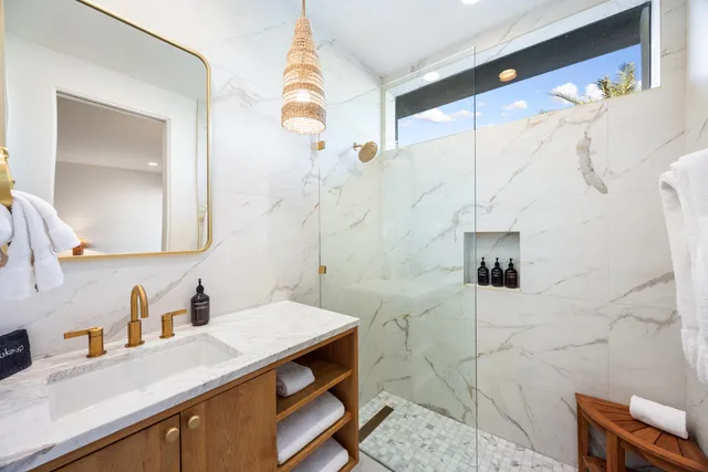 a bathroom with a granite countertop sink a toilet and shower