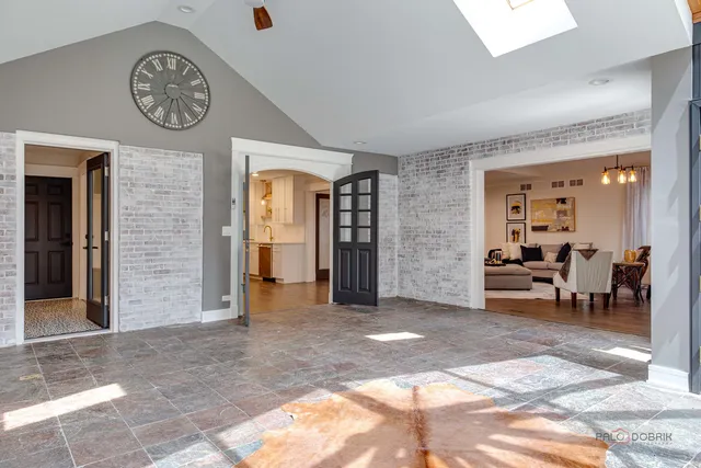 a view of a dining room and livingroom with furniture wooden floor a chandelier