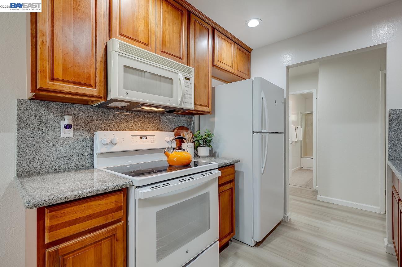 9005 Alcosta Boulevard, Unit 199 San Ramon, CA 94583 - Photo 27 of 57 a kitchen with stainless steel appliances granite countertop a refrigerator and a stove top oven