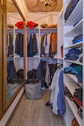 a view of walk in closet with clothes and shoes