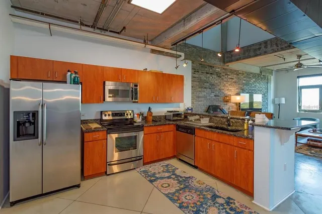 a kitchen with stainless steel appliances granite countertop a stove top oven a sink and dishwasher