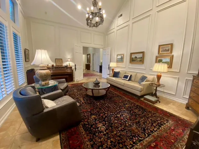 a living room with furniture chandelier and a rug