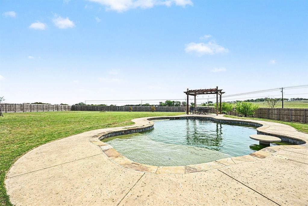 104 Stanford Lane Springtown, TX 76082 - Photo 26 of 28 a view of a swimming pool with a garden