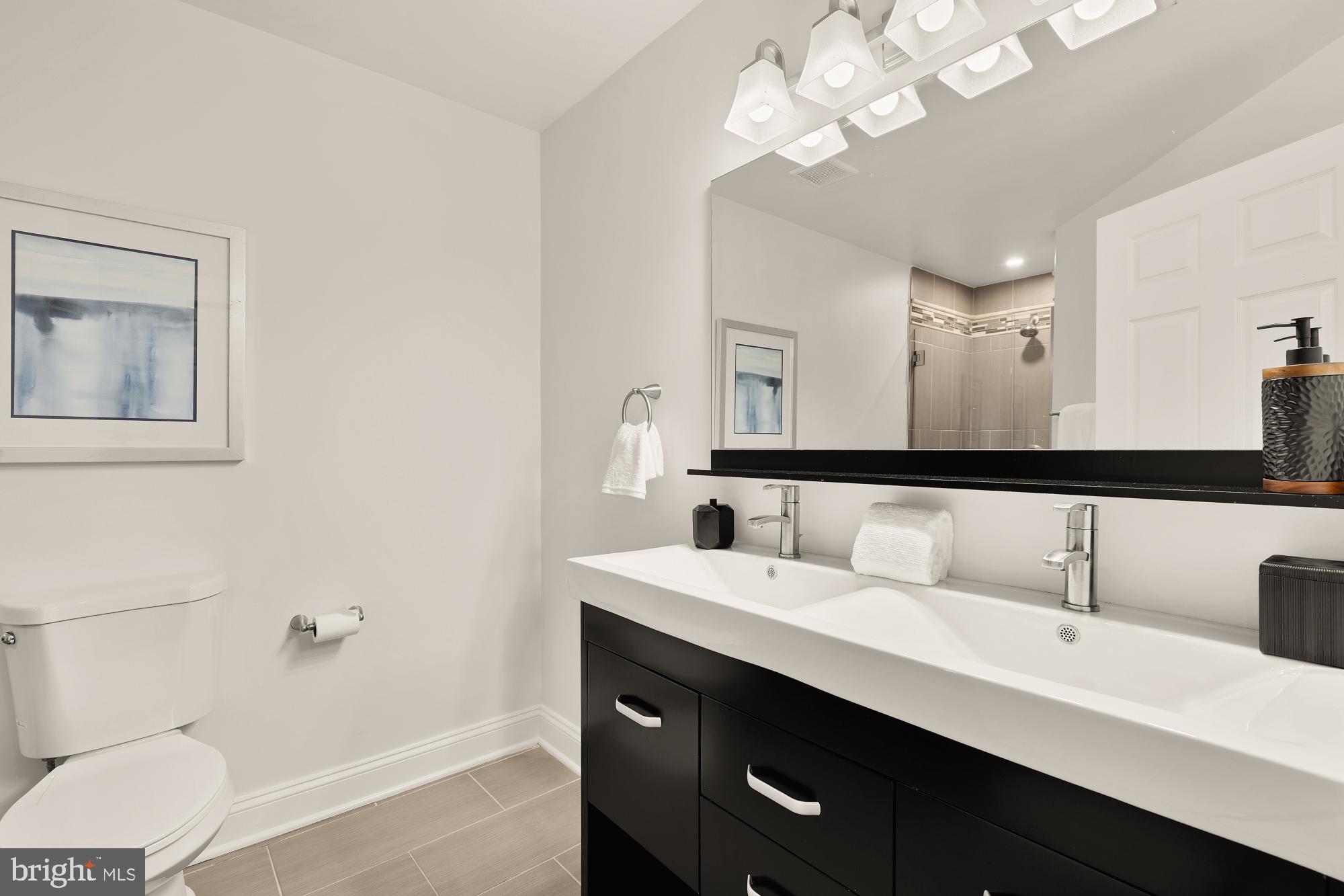 2004 11th Street Northwest, Unit 124 Washington, DC 20001 - Photo 29 of 35 a en suite bathroom with a double vanity sink a mirror and a toilet