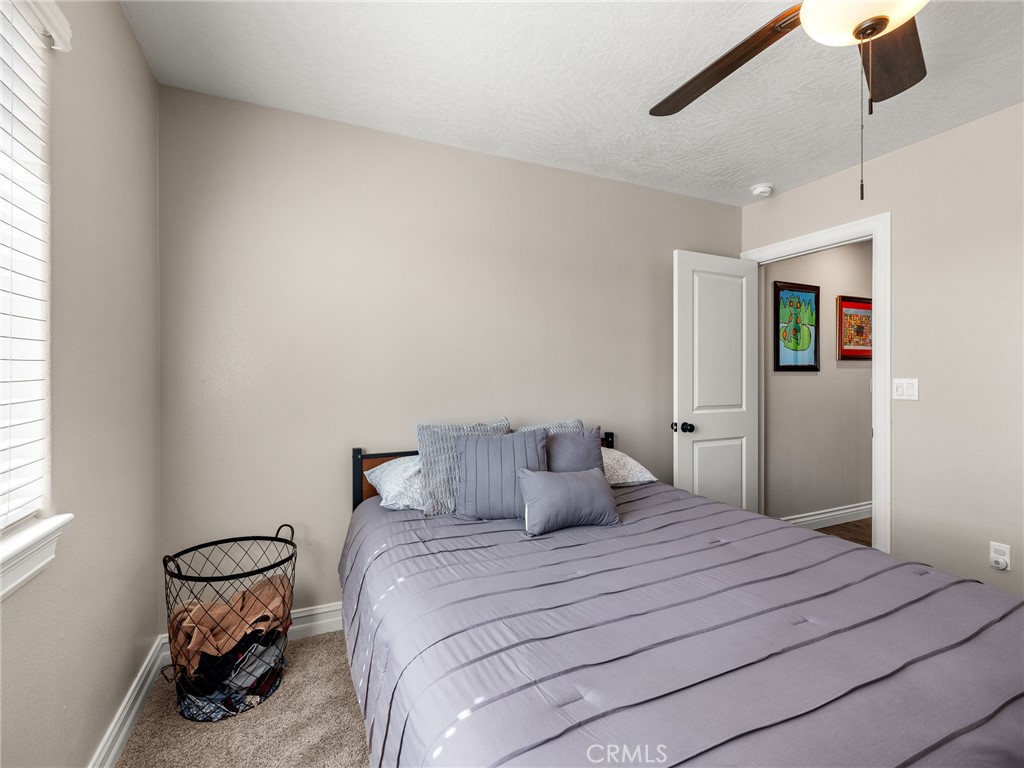 15620 Erie Road Apple Valley, CA 92307 - Photo 22 of 53 a bedroom with a bed and a chandelier